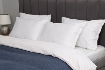 Many soft pillows on bed at home, closeup