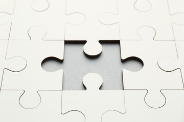 Obraz premium White puzzle with missing piece on grey background, closeup