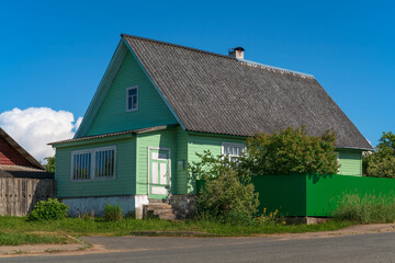 View of a traditional Russian wooden village house on the main street of Izborsk - Pechorskaya - on a sunny summer day, Izborsk, Pskov region, Russia