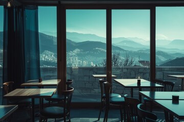 Interior of a cafe with a panoramic window overlooking the mountains