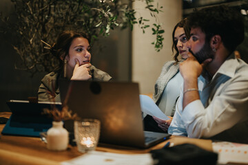Businesspeople working together late at night in a coffee bar, collaborating on a project and discussing deadlines