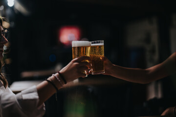 Close-up of friends toasting with glasses of beer in a cozy pub, celebrating and enjoying a relaxed evening together.