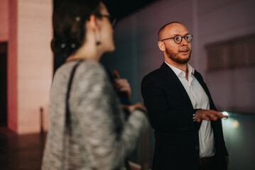 Business professionals engaging in conversation and networking during a nighttime event, discussing strategies and building connections.