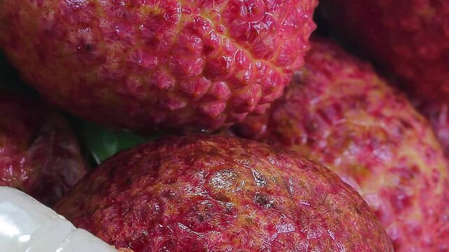 Fresh ripe juicy lichi fruit bunch pan to pealed white sweet flesh on white background wooden board