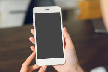 Hand holding smartphone mockup of blank screen for graphic display montage.