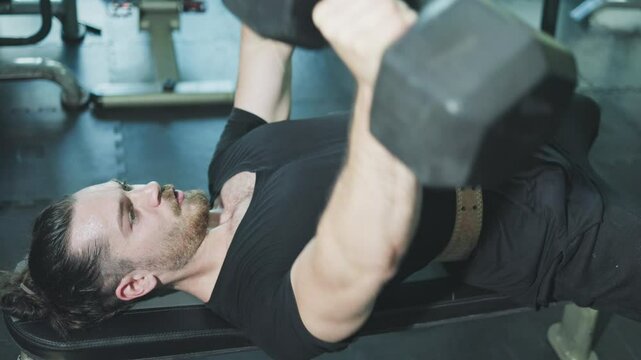 man exercising with Dumbbell Bench Press at the gym