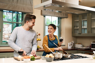 Smile, couple and cooking with love in kitchen for bonding with food, wine and conversation with...