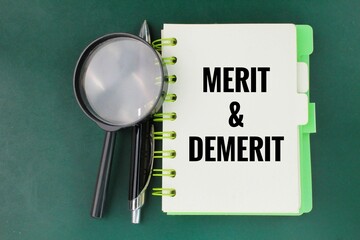 a pen, a magnifying glass and a book with the words MERIT and DEMERIT. Merits refer to the...