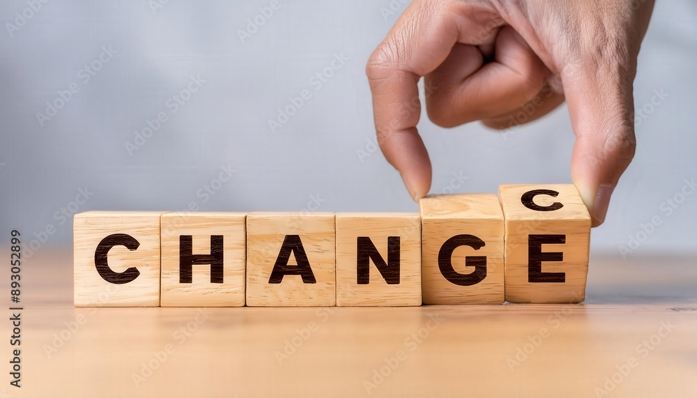 Poster a hand is holding a wooden block with the letters change written on it. the block is being broken in