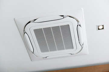 Ceiling-mounted air conditioner with integrated light, showcasing modern HVAC design.