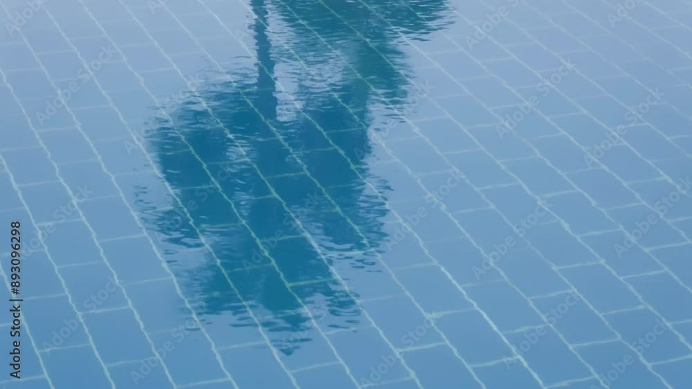 Poster empty swiiming pool, ripple effect on water surface and reflected palm tree