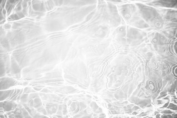 White water with ripples on the surface. Defocus blurred transparent white colored clear calm water surface texture with splashes and bubbles. Water waves with shining pattern texture background.