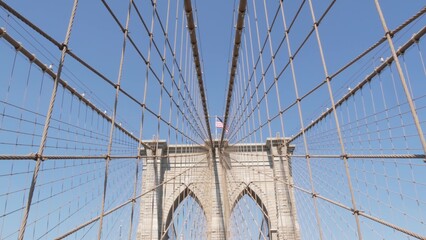 Fototapeta premium Brooklyn Bridge to Manhattan downtown, cables and blue sky. New York City iconic symbol, USA travel destination. Architecture of United States of America, tourist landmark. Famous cable-stayed bridge.