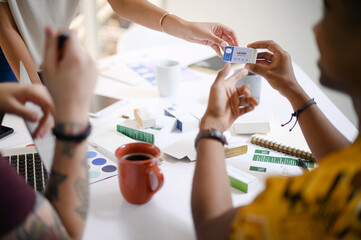 Business people, hands and box with design for pharmaceutical packaging, logistics or planning at office. Closeup of employees discussing drug, product or container for brand development at workplace