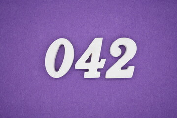 The numbers are made of white paint wood, placed on the background as a purple paper.