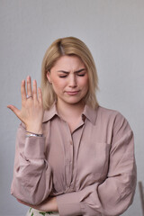 A portrait of an attractive young professional woman with blonde hair, wearing a light brown shirt