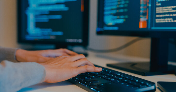 Closeup young adult Asia female freelance typing write prompt AI bot IT app program nomad, video game, terminal with coding language, designer, big data center on desktop computer in night office.