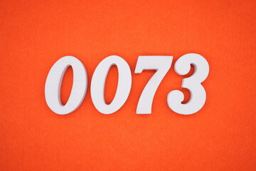 The numbers are made of white painted wood. Placed on the floor was orange paper.