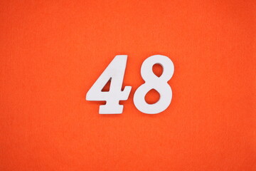 The numbers are made of white painted wood. Placed on the floor was orange paper.