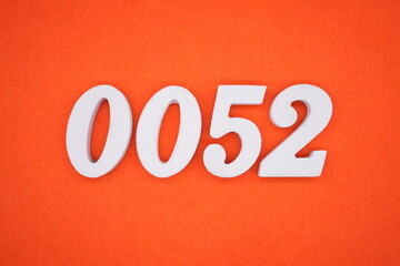 The numbers are made of white painted wood. Placed on the floor was orange paper.