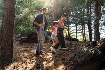 Family hiking in pine forest, parents and daughter exploring nature, outdoor adventure and active...