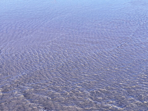 Blue sea water rippled calm surface on sandy beach