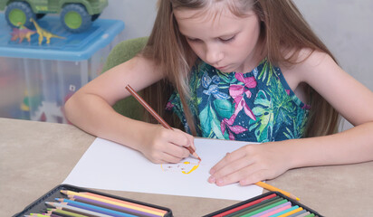 School girl draws with colored pencils. Art creativity and hobby. Childhood and activities at home.