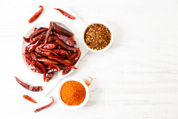 Dried red chilies on white wooden table.