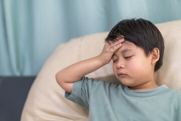 Portrait of sick depressed unhappy child boy touching on head feel suffering head ache pain flu high fever, alzheimer, cancer, stroke, parkinson, disease, cerebral haemorrage, encephalitis, dementia