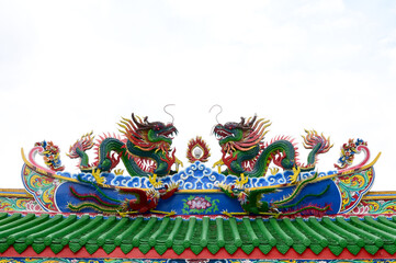 Obraz premium The Beautiful Double Chinese dragons on the temple roof with blue sky background at Guan Yu Shrine at Bangkok, Thailand