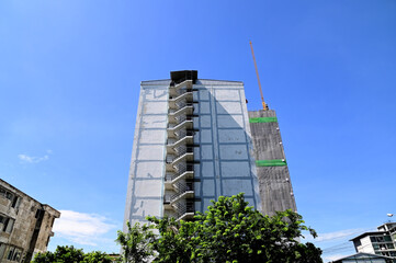 Fototapeta premium BANGKOK, THAILAND - July 23, 2024 : The construction of new building in the city with Blue Sky Background. Construction Concept in Thailand.