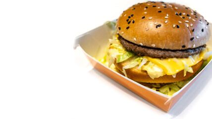 An appetizing burger in a box on the table. Fast food concept. Place for text.