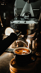 Espresso pouring from coffee machine at cafe,Brewing the espresso coffee from the machine warm tone.