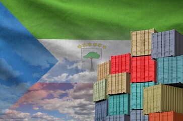 Equatorial Guinea flag and big stack of shipping cargo containers in docks with sky background close up