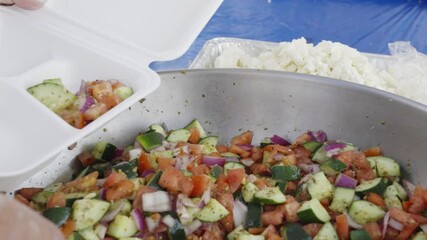 Scooping out portions at a Hellenic Festival. - Powered by Adobe