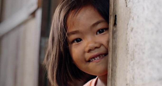 A 5 year old girl in Thailand, Southeast Asia which lives with her single mother, a poor farm worker, in the employer's worker housing in a rural area.