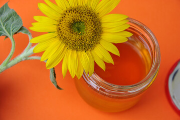sunflower flower and open glass jar of honey. selective focus. natural fresh sunflower honey