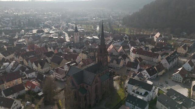 Drone orbits Nagold city church in red brick architecture, religious swabian place of prayer.