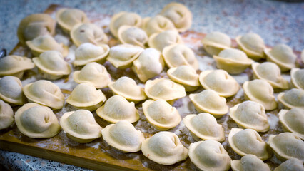 Homemade dumplings close-up. handmade dumplings on a wooden board, selective focus, tinted image, traditional Russian dish,
