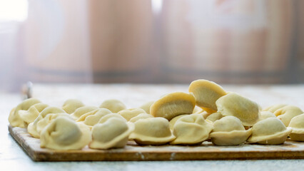 Homemade dumplings close-up. handmade dumplings on a wooden board, selective focus, tinted image, traditional Russian dish,