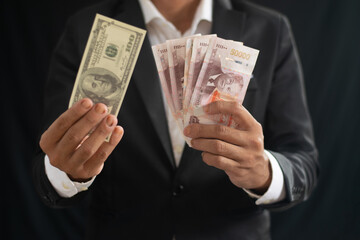 Businessman holding dollars and Lao kip, business concept of finance, investment