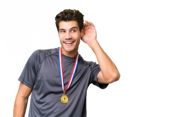 Young caucasian man with medals over isolated background listening to something by putting hand on the ear