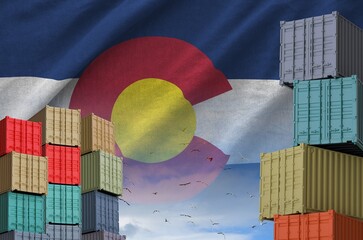 Colorado US state flag and big stack of shipping cargo containers in docks with sky background...