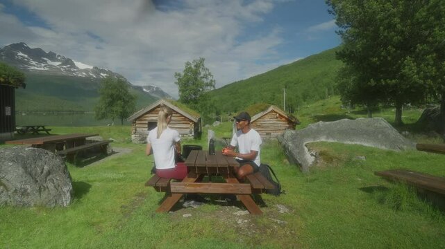 Two people enjoying lunch at Rennd&oslash;lsetra farm in Innerdalen, Norway with scenic mountain views