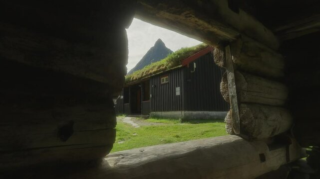A young couple hiking through a rustic village in Innerdalen, Norway, with mountain views, midday