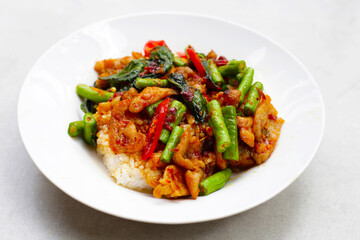 Rice topped with stir fried pork and red curry paste with yard-long bean