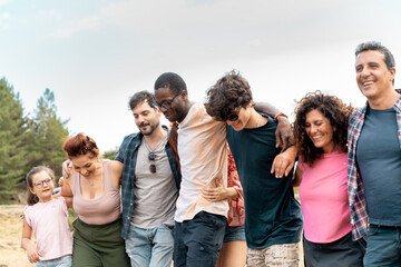 Diverse group embracing outdoors friendship community togetherness multicultural family summer happiness