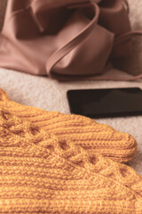 Knitted warm clothes. Women's hobby. Knitted pattern. Knitted fashion. Handmade things. Home comfort. Girl with knitting in hands. Relaxing leisure time in autumn and winter.