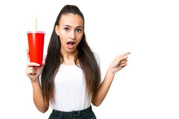 Young Arabian woman holding soda over isolated chroma key background surprised and pointing finger to the side