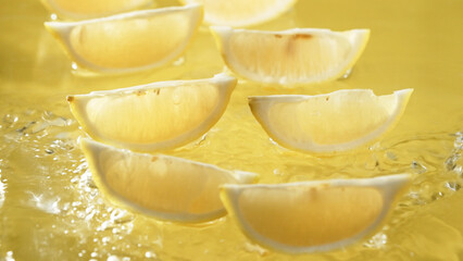 Macro of a fresh lemon slices arranged on yellow background. Close up of citrus fruit or lemon sliced placed at red backdrop. Citrus composition concept. Design for greeting card, wallpaper. Pabulum.